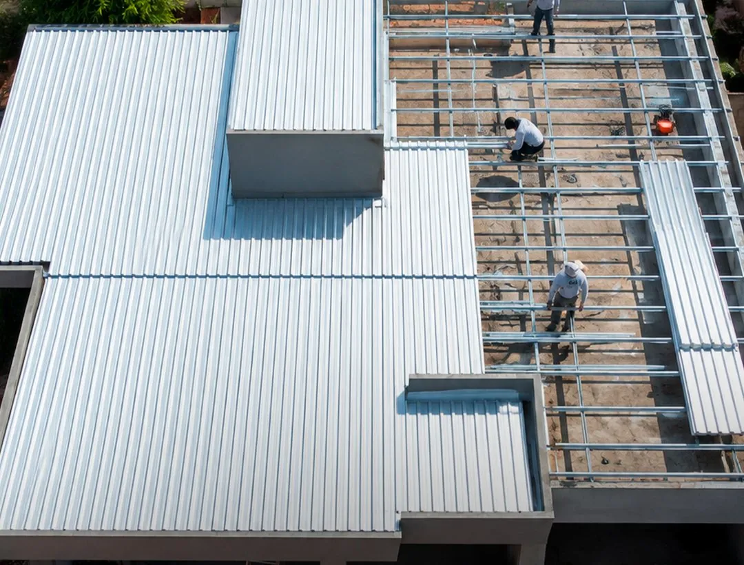 Equipe montando estrutura galvanizada e telhado em obra residencial